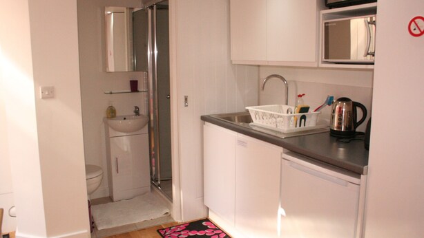 A compact kitchen with a sink, microwave, and a small countertop. - Self-contained New Studio with independent entrance in an up-market quiet area. (London)