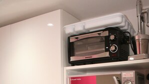 A kitchen with white cabinets, a microwave, a toaster, and a kettle on the counter. - Self-contained New Studio with independent entrance in an up-market quiet area. (London)