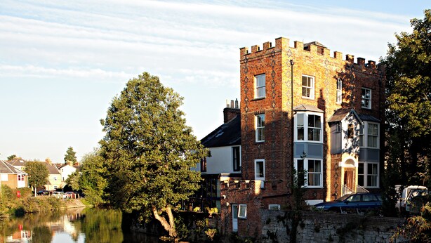 A riverside building with a brick facade, large windows, and a reflection in the water. - Luxury Studio with balcony over the River Thames in historic centre of Oxford (Oxford)
