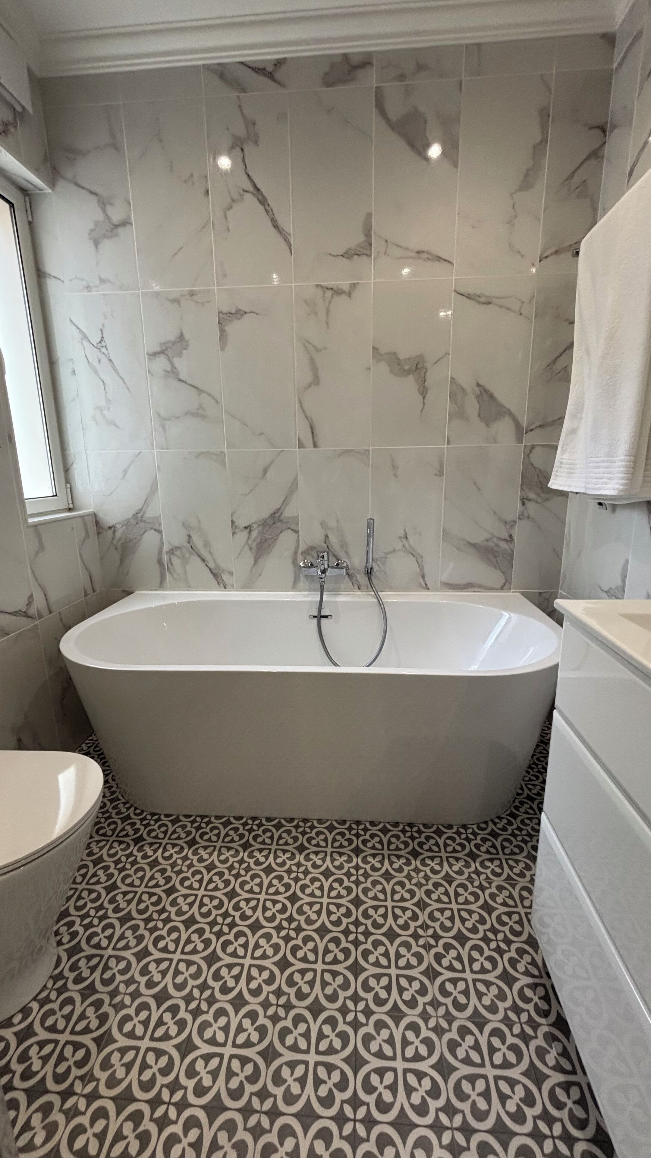 Un baño con una bañera independiente, un inodoro y un lavamanos.