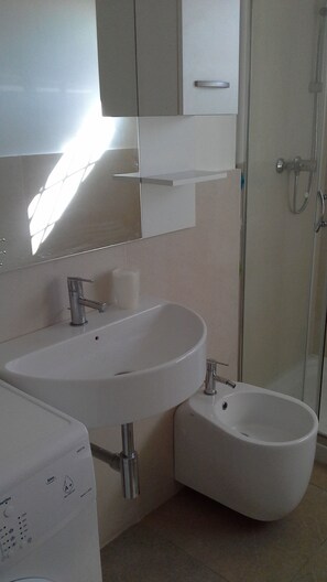 Een douche, een haardroger, een bidet, handdoeken