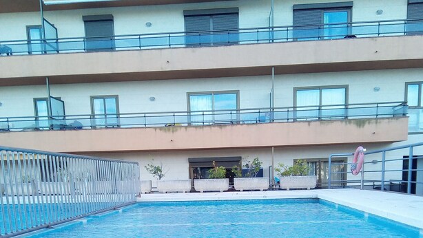 A swimming pool with a clear blue surface, surrounded by a concrete deck. There are potted plants and a lifebuoy on the deck. - AIR CONDITIONING, POOL, BARBECUE,PARKING,WI-FI. PERFECT FOR FAMILIES AND COUPLES (Platja d'Aro)