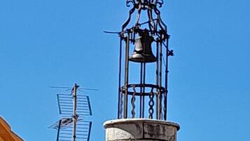 Ein Gebäude mit einem Glockenturm, einem Wetterhahn und einem Ziegeldach.
