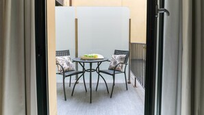 A balcony with a table and two chairs, a view of the building's exterior, and a door leading to another room. - Bright and spacious, in the picturesque setting of a former cinema (Bologna)