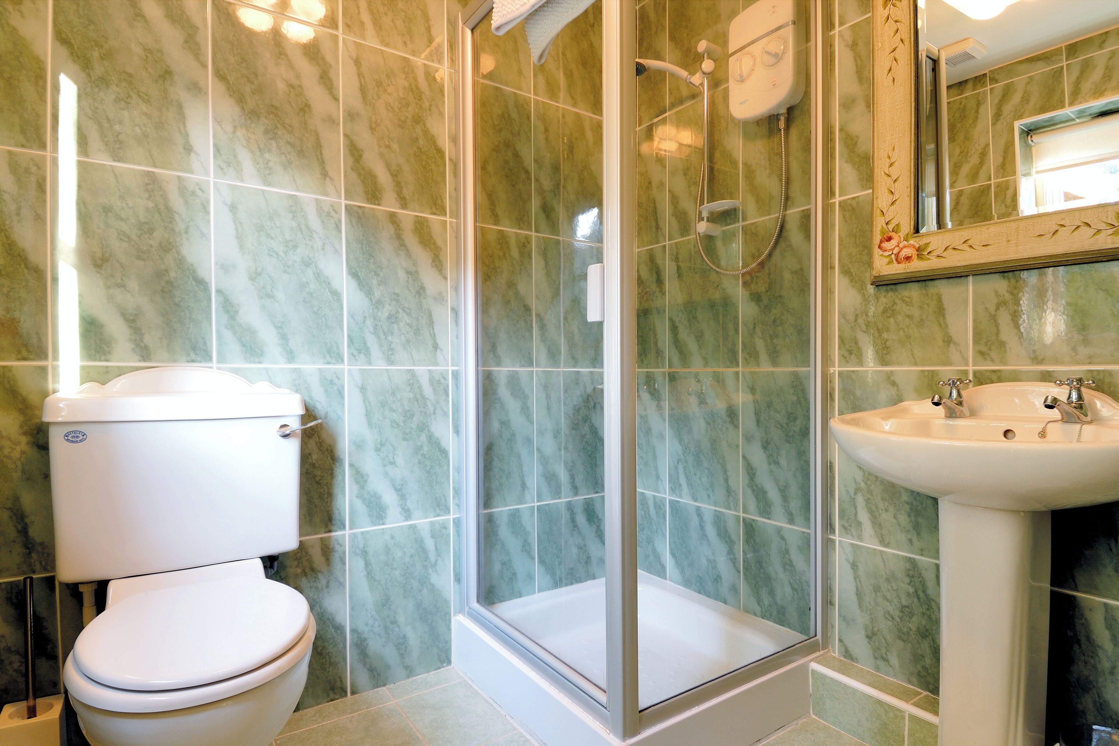 Ein Badezimmer mit Toilette, einer Duschkabine und einem Waschbecken.