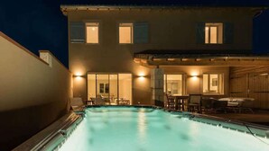 Une maison à deux étages avec une piscine dans le jardin.
