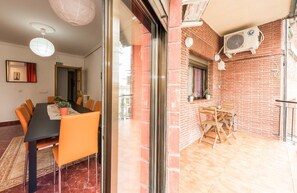 A dining area with a table and chairs, a kitchen area with a window, and a brick wall. - Spacious apartment with terrace. 3bed in the center (Madrid)