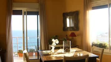 Enjoy a meal with a view of the sea from this dining area, featuring a table for two and a beautiful view.