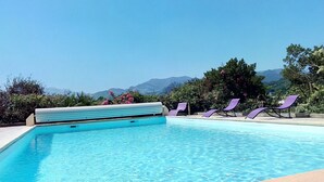 En klar, blå pool med udsigt til bjerge i baggrunden.
