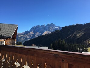 A mountain cabin with a wooden balcony overlooking a mountain range. - Luxury Ski-in/Ski-out Apartment with spectacular views of the Dents du Midi (Val D'Illiez)