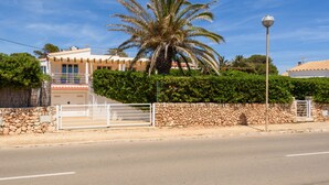 A coastal property with a stone wall, a palm tree, and a white gate. - IDEAL LARGE FAMILIES, facing the sea and a few meters from the beach of Binibeca (Binibequer)
