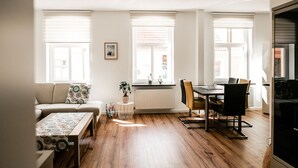Un salon moderne comprenant un canapé, une table à manger avec des chaises, une table basse et un radiateur.