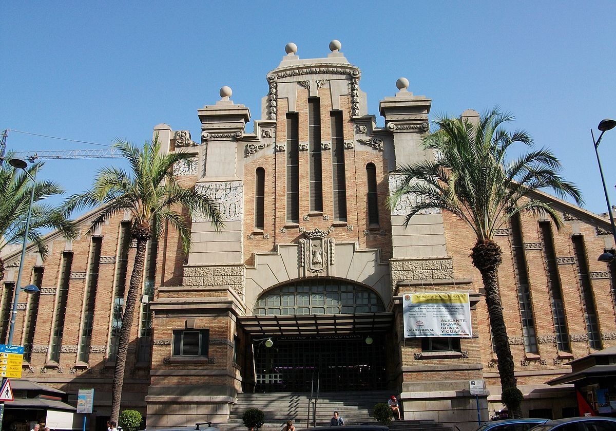 Un grand bâtiment imposant, richement décoré, avec une entrée monumentale, de hautes colonnes et des éléments décoratifs.