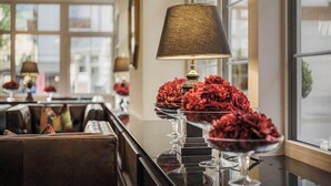 A restaurant interior with a long counter, multiple tables, and a large window. - Norica Hotel (Bad Hofgastein)