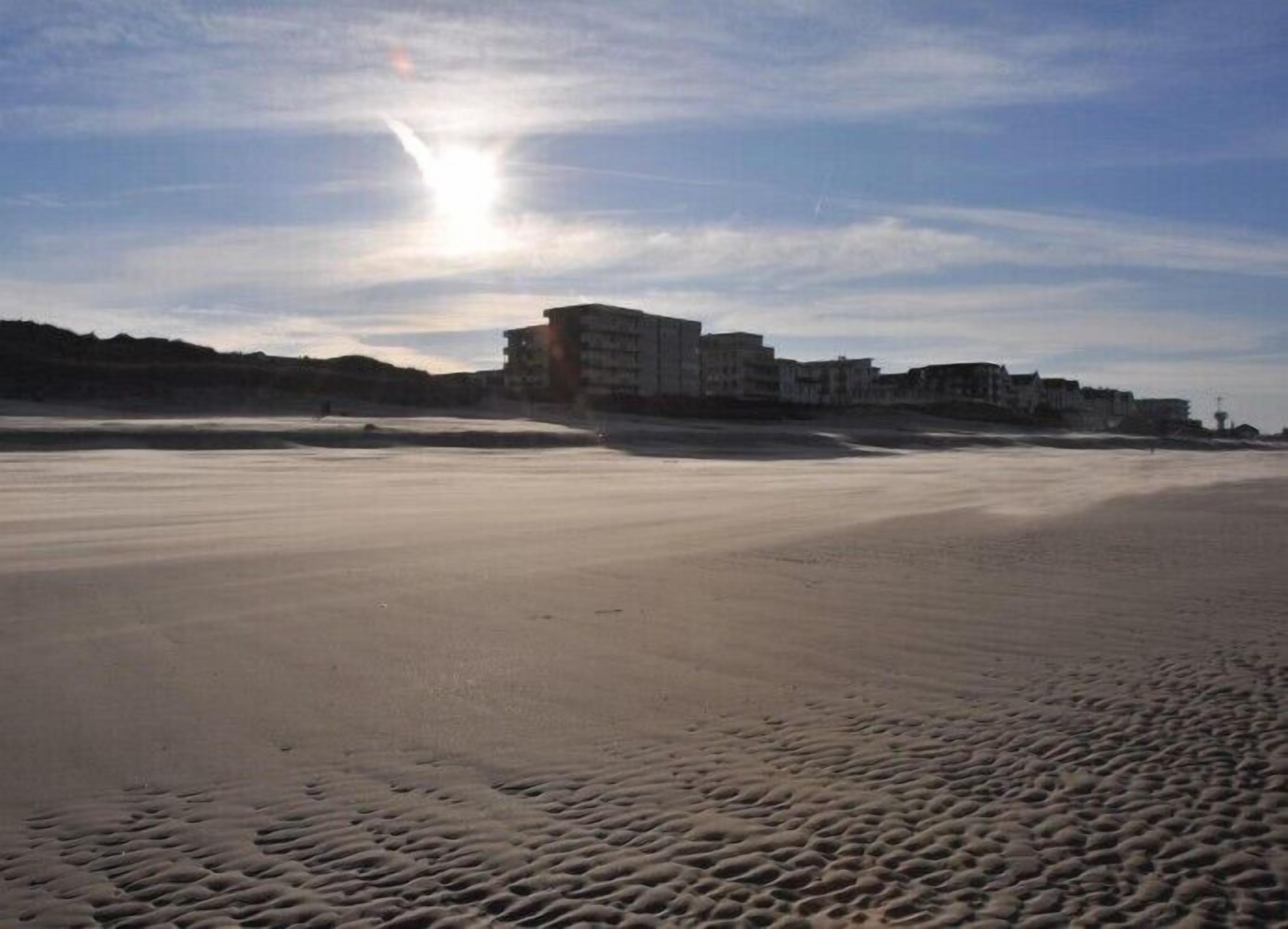 A beach with a building in the background.