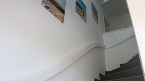 A staircase with a curved wall and three framed pictures. - F86 - balcony, close to the Bodden, Baltic Sea 6 km away, WLAN (Born)