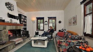 Ein gemütliches Wohnzimmer mit Kamin, einer Couch, einem Couchtisch und einem Bücherregal.