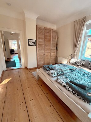 Una camera da letto con un letto grande, un armadio in legno e vista sull'esterno.