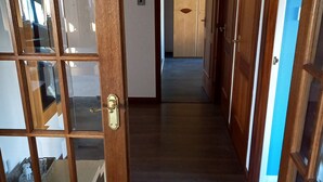 A hallway with wooden doors and a tiled floor.
