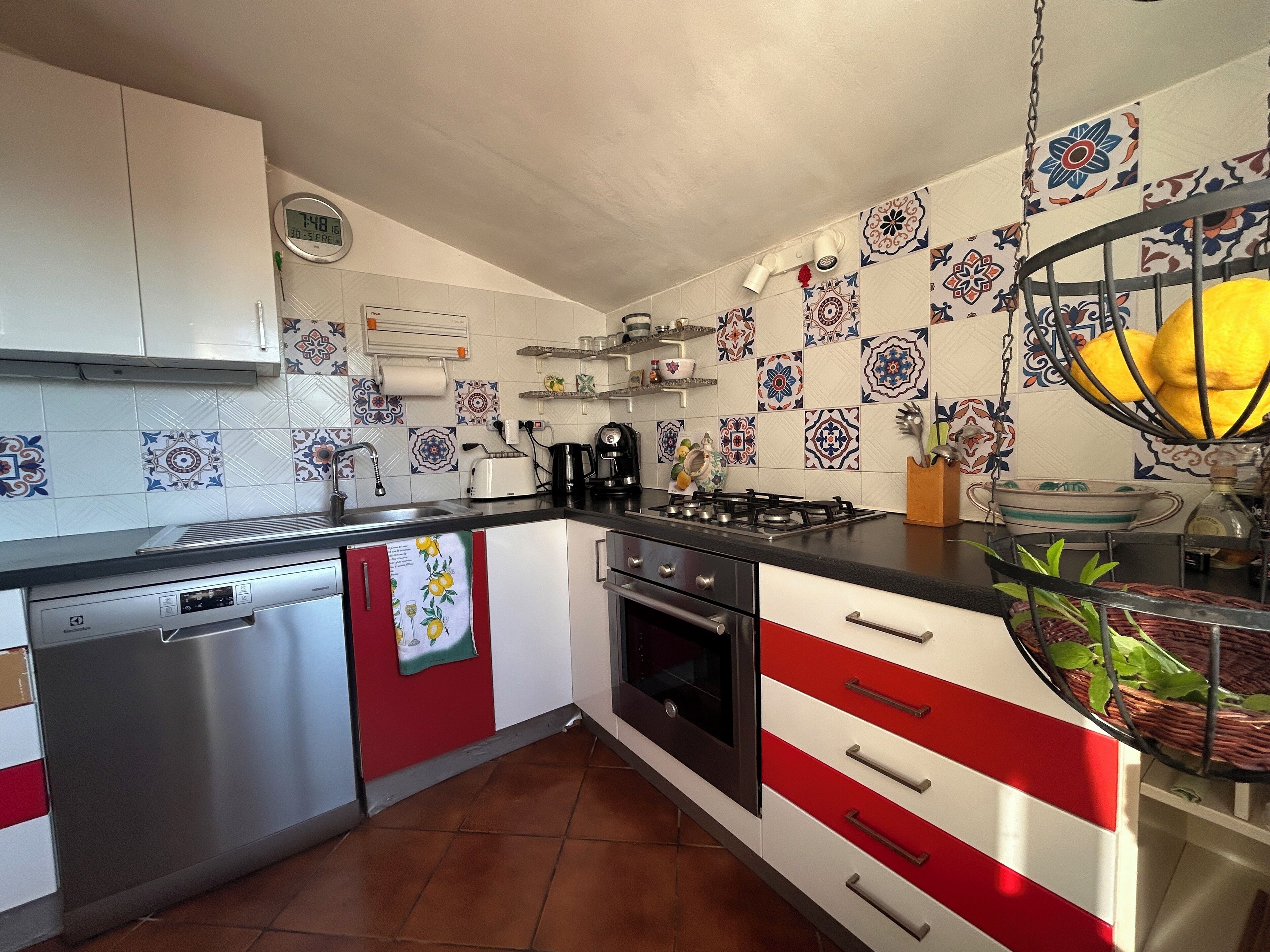Una cocina con estufa, lavamanos y electrodomésticos modernos.