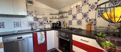 Una cocina con estufa, lavamanos y electrodomésticos modernos.