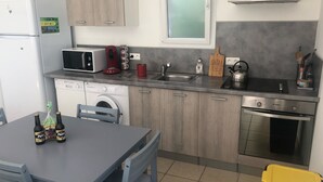 Eine kompakte Küche mit Mikrowelle, Toaster, Spüle und einem kleinen Backofen.