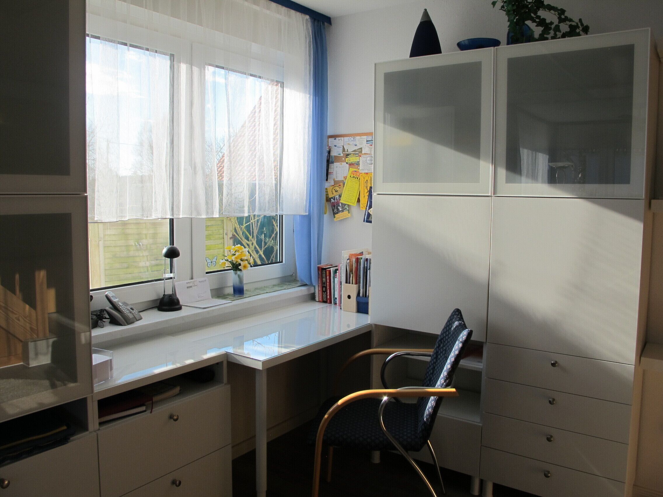 A compact office space with a desk, chair, and storage cabinets.