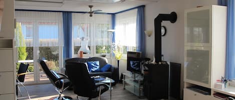 Uma sala de estar moderna com um sofá, uma televisão e uma lareira.