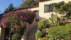 A stone staircase leading to a building with a tiled roof and a window with shutters. - Provençal villa with sea views & Mediterranean garden, beaches, Wi-Fi, A/C (La Croix-Valmer)