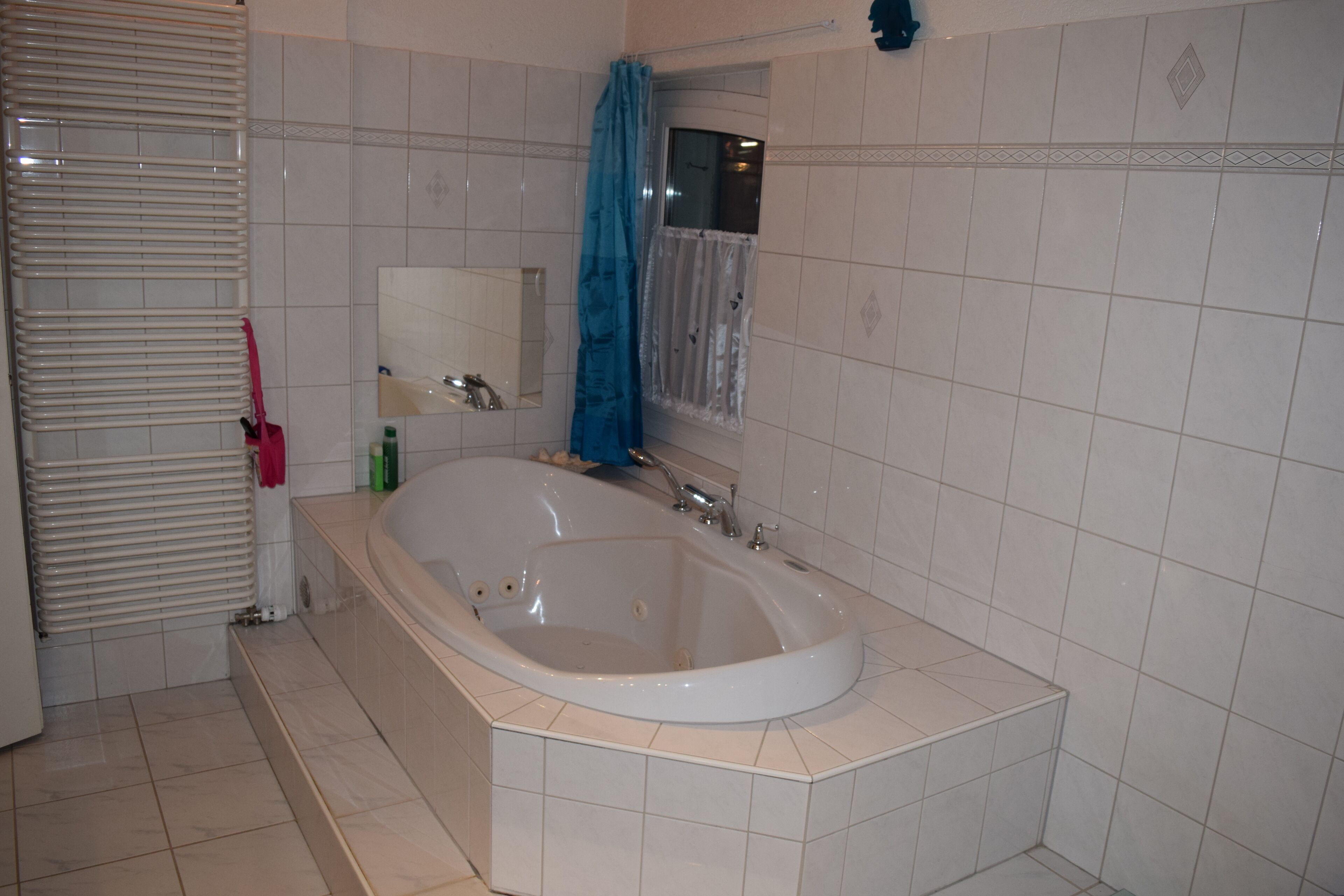 Une salle de bain avec une baignoire sur pieds, un porte-serviettes et un miroir.