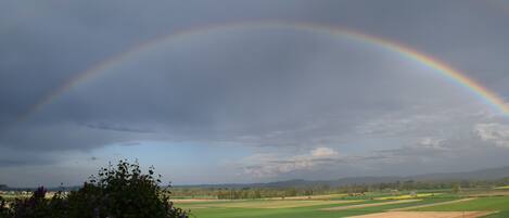 A landscape with a rainbow over a field.