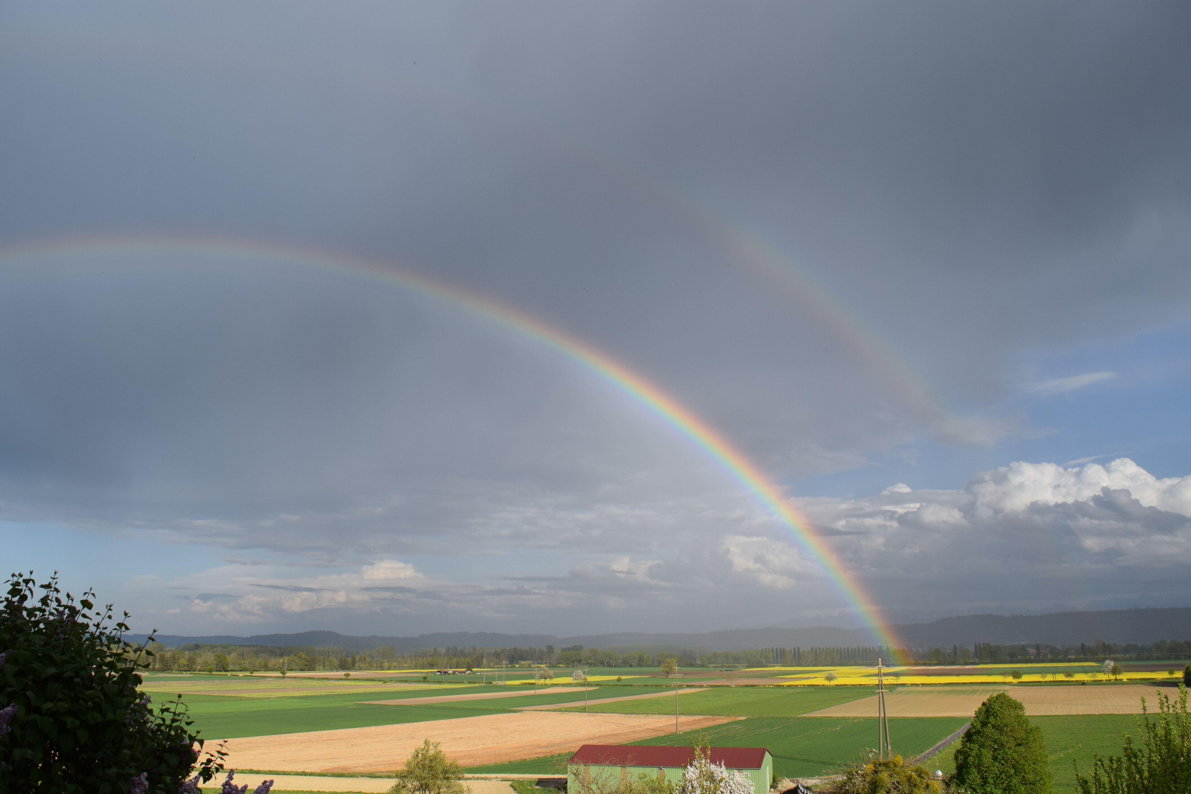 A landscape with fields and a rainbow.