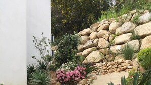 Eine Steintreppe, umgeben von verschiedenen Pflanzen und Blumen.