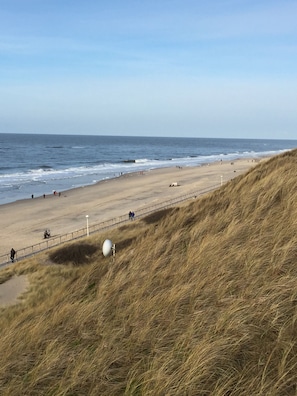 A beach with a sandy shore, a grassy dune, and the ocean in the background. - 5 star (DTV) feel-good holiday home close to the beach and Friedrichstrasse (Sylt)