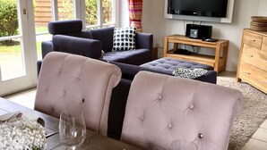 A living room with a sofa set, a television, and a wooden side table.