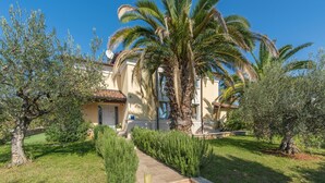 A Mediterranean-style villa with a well-maintained garden, a stone pathway, and a palm tree. - Dream villa with large swimming pool, 800m from the sea with 5 bedrooms 4 bathrooms (Porec)