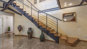 A staircase with a metal railing, a wall-mounted mirror, and three large vases on the floor. - Dream villa with large swimming pool, 800m from the sea with 5 bedrooms 4 bathrooms (Porec)