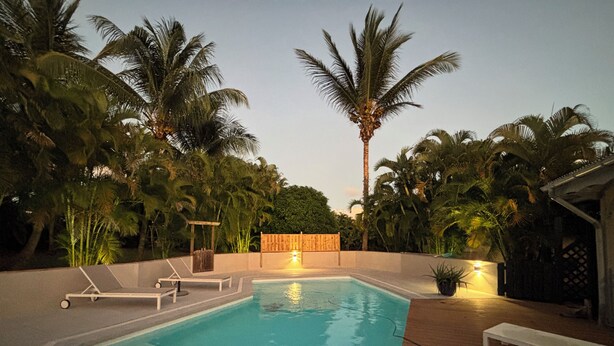 A rectangular swimming pool with a wooden deck surrounding it, lounge chairs, and a wooden fence. - BEAUTIFUL COUNTRY PROPERTY WITH PRIVATE POOL. HOLIDAYS TO YOU! (SAINTE ANNE)