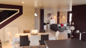 A modern living room with a dining area, a staircase, and a kitchen in the background. - MODERNITY, COMFORT, SWIMMING POOL, VIEW AT THE FOOT OF MONT VENTOUX (Modène)