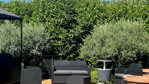 An outdoor patio with wicker furniture, a round table, and a pergola. - MODERNITY, COMFORT, SWIMMING POOL, VIEW AT THE FOOT OF MONT VENTOUX (Modène)