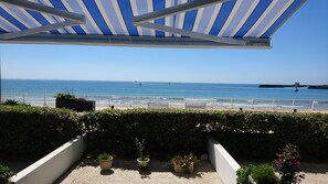 Un balcon avec vue sur la mer, une balustrade et des plantes en pot.