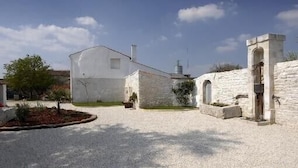 Un edificio blanco con un pequeño jardín delantero.