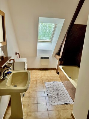 A small, narrow bathroom with a skylight, a sink, a bathtub, and a window. - Large family home (15 people) with swimming pool (La Dornac)