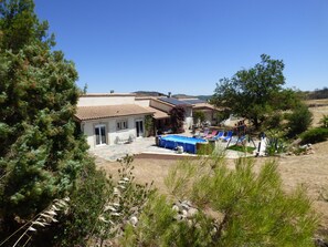 Une propriété résidentielle dotée d’une piscine, d’un espace extérieur aménagé et située sur une colline, offrant une vue panoramique.