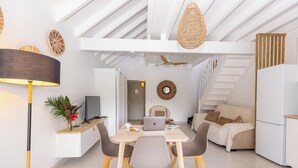 Eine moderne Küche mit Essbereich, weißen Schränken und einer Treppe.