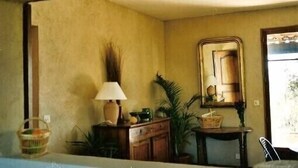 A room with a wooden cabinet, a lamp, a mirror, and a potted plant. - House with private pool, Luberon nature park, near Lourmarin. (Puyvert)