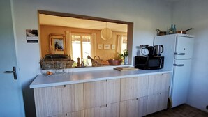 A compact kitchen with a central island, a microwave, a kettle, and a refrigerator. - House with private pool, Luberon nature park, near Lourmarin. (Puyvert)