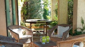 A patio with wicker furniture, a table, and chairs. There are plants and a view of the outdoors. - House with private pool, Luberon nature park, near Lourmarin. (Puyvert)