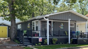 A small, single-story building with a porch, a yellow door, and a sign for 'Dobbins Grille & Bar'. - Ocean Lakes Cottage Quiet Street, Shady Lot, 5000 Section Sleeps 7 (Myrtle Beach)