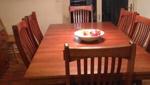 A dining room with a wooden table and chairs, a chandelier, and a bowl of fruit on the table. - Oaks at Wasatch--call for discounted monthly off-season corporate rates (Cottonwood Heights)